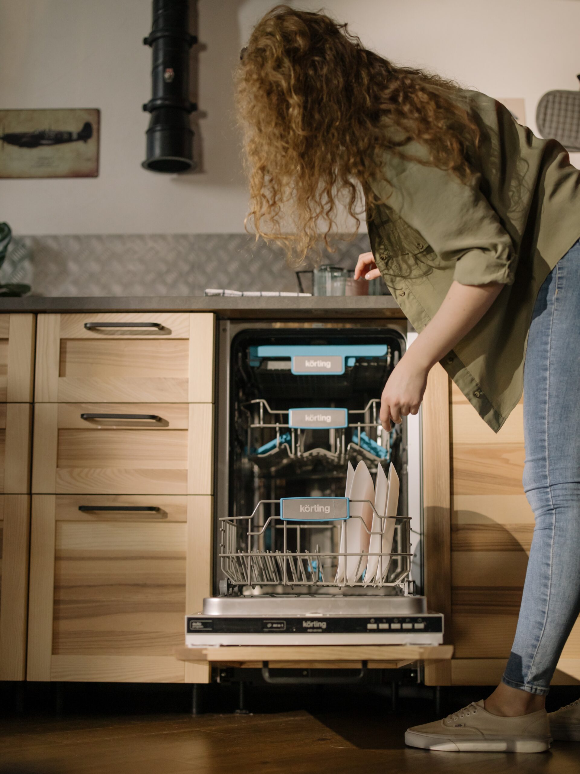 Woman loading dishes into a dishwasher.