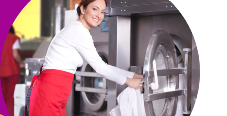 Woman operating commercial laundry machine.