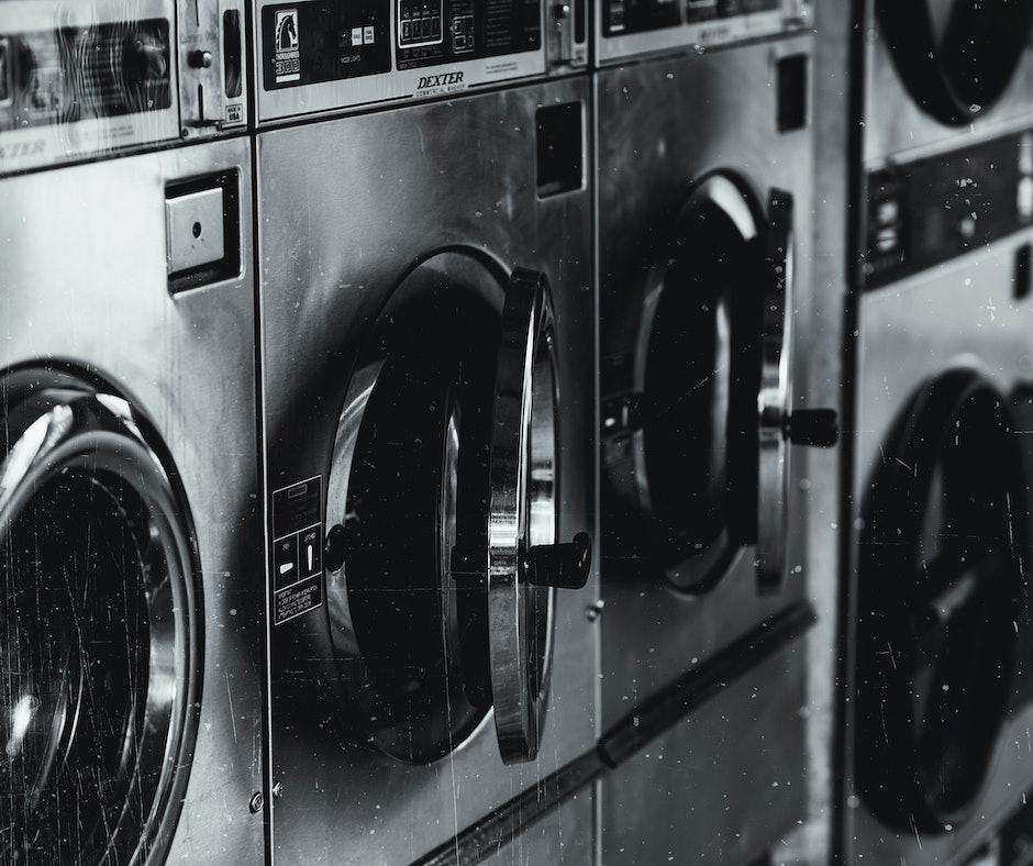 Row of industrial washing machines in laundromat.
