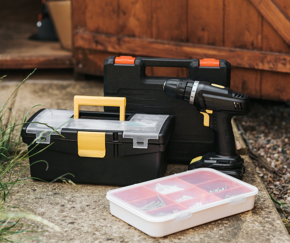 Cordless drill and toolboxes outdoor.