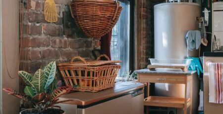 Rustic kitchen with wicker baskets and brick wall.