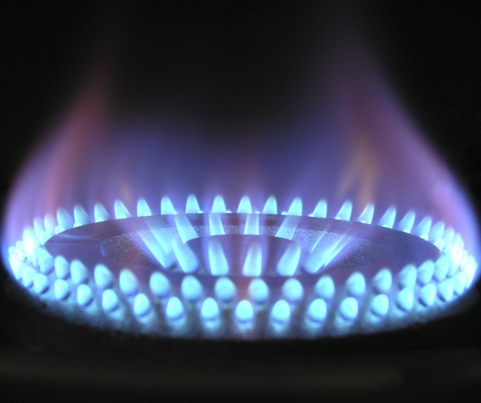 Blue flames on a gas stove burner.