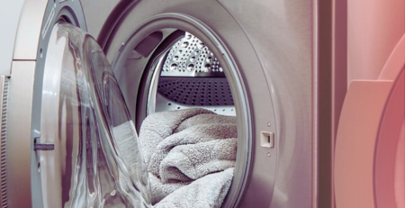 Front-loading washing machine with towels inside.