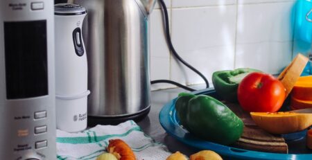 Kitchen countertop with vegetables and electric kettle.
